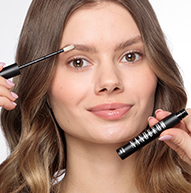 Woman applying Nanobrow eyebrow conditioner, looking at the camera