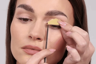 تنزع العارضة القضبان من جفنيها وتضع رموشها بلطف